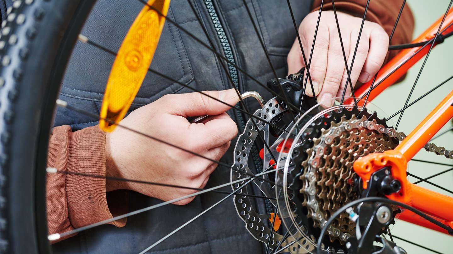 Mecânico ajustando o câmbio traseiro de uma bicicleta